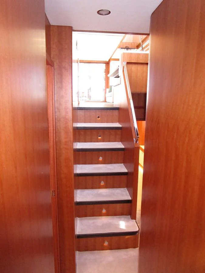 A well-crafted wooden staircase leads to the upper deck of the yacht. aboard INDIGO Yacht for Sale