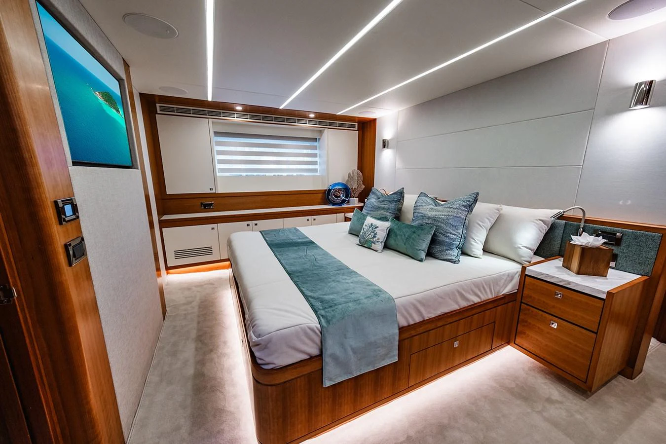 The stateroom features a luxurious bed with elegant bedding and modern lighting. aboard INDIGO Yacht for Sale