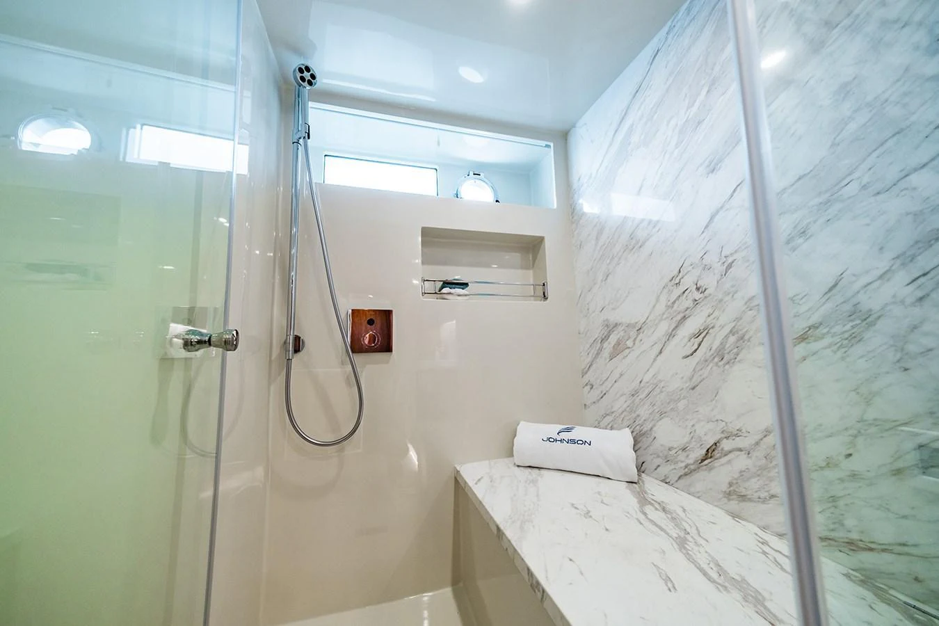 The yacht's bathroom features a luxurious shower area with marble accents and modern fixtures. aboard INDIGO Yacht for Sale