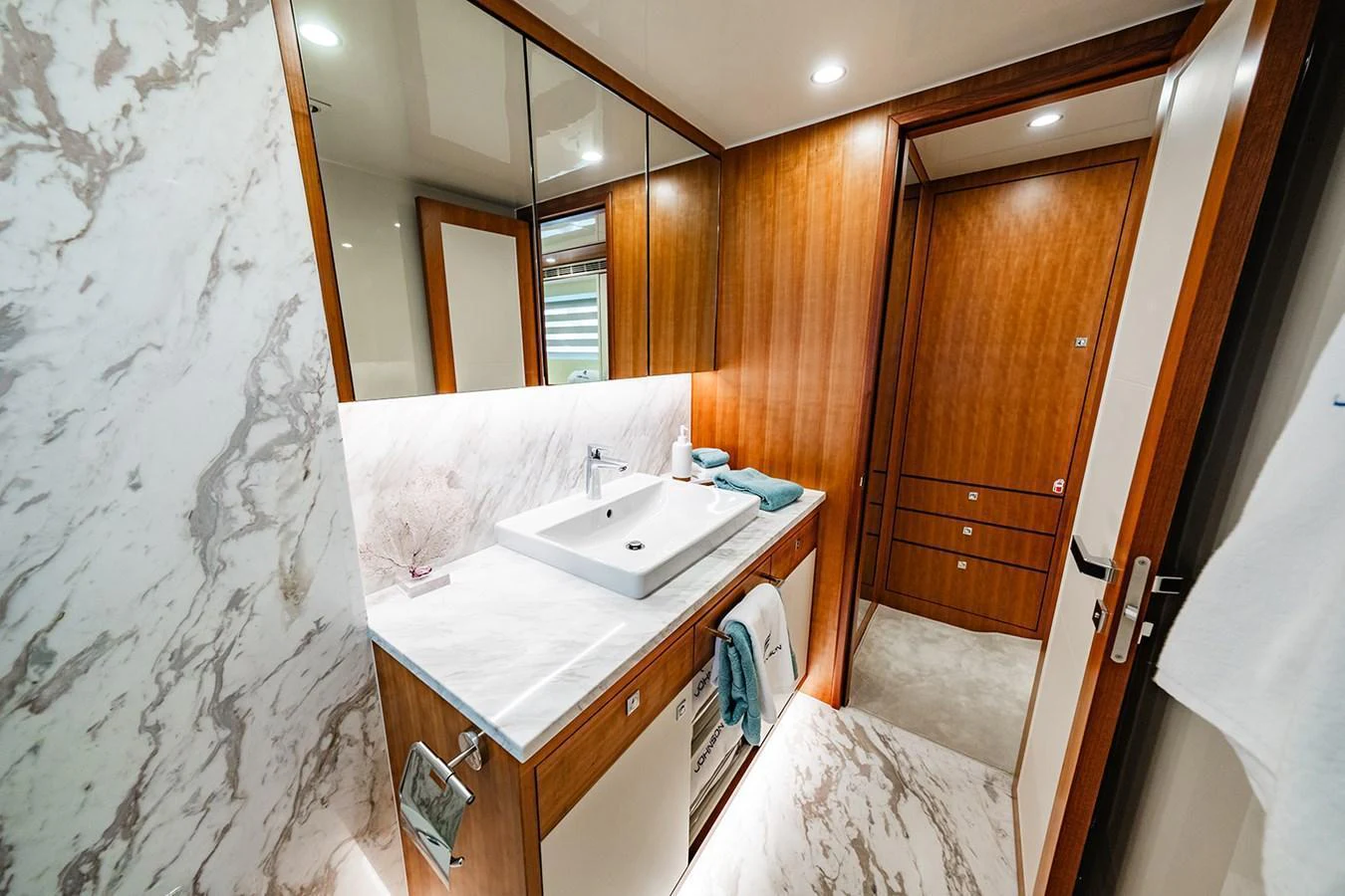 The yacht's bathroom features elegant marble surfaces and warm wooden accents. aboard INDIGO Yacht for Sale
