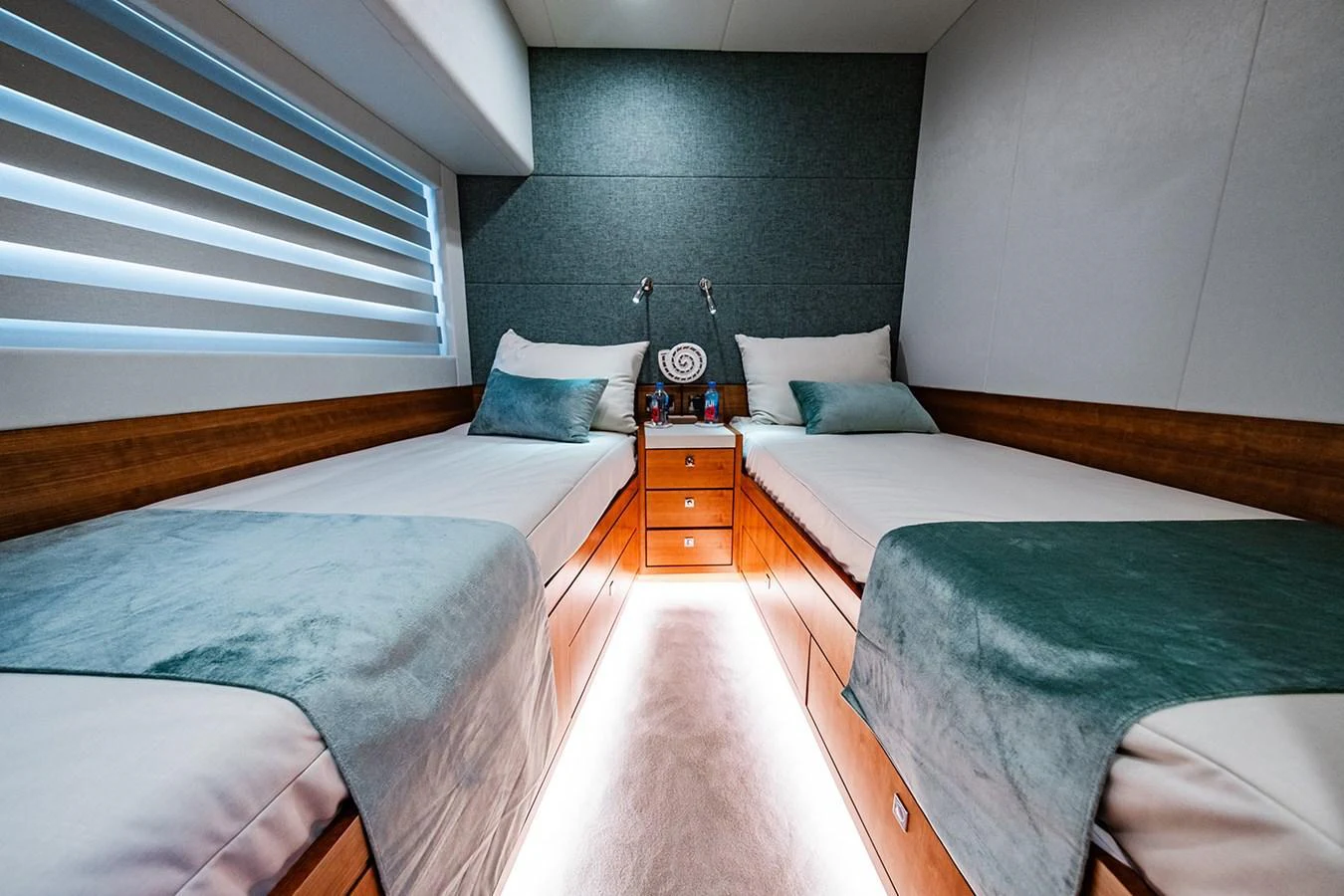 The twin stateroom offers a cozy and modern retreat with two single beds and elegant lighting. aboard INDIGO Yacht for Sale
