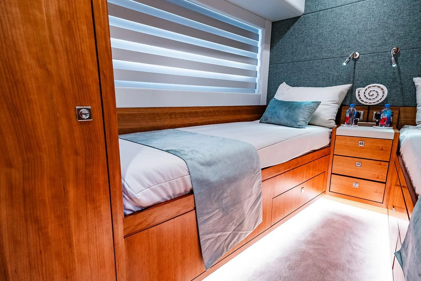 The guest stateroom features twin beds with elegant wood finishes and soft ambient lighting. aboard INDIGO Yacht for Sale