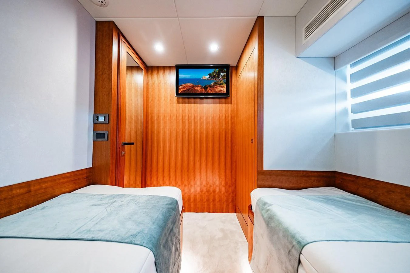 The guest stateroom offers a cozy and inviting space with twin beds and modern amenities. aboard INDIGO Yacht for Sale