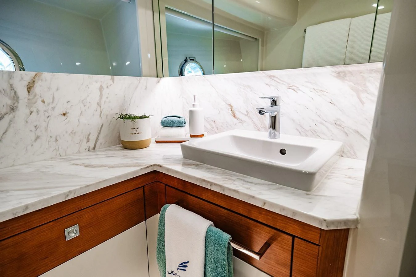 The yacht's bathroom features a sleek sink area with marble countertops and modern fixtures. aboard INDIGO Yacht for Sale