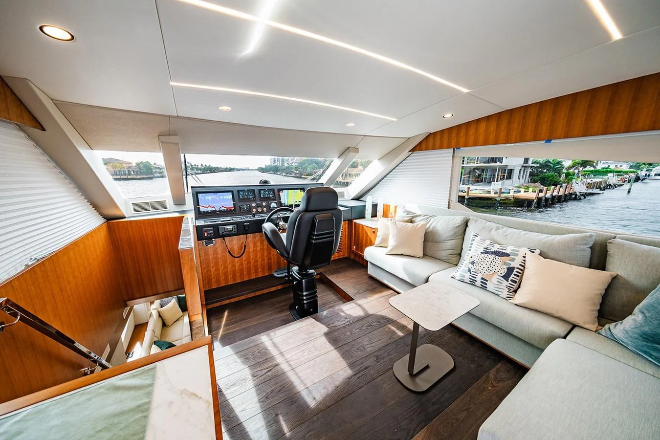 The helm area features a modern control station with a comfortable seating area and panoramic views. aboard INDIGO Yacht for Sale
