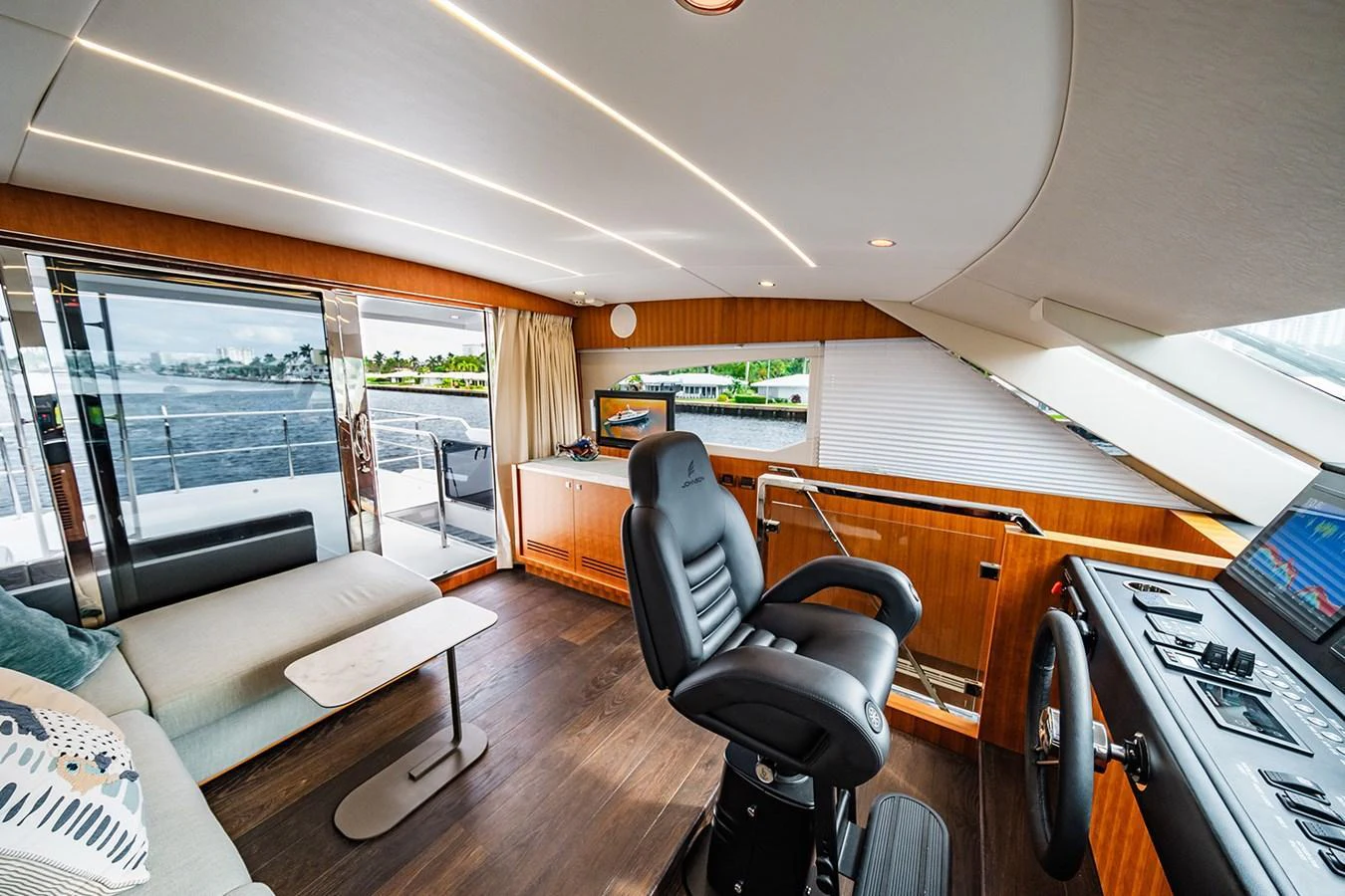 The helm area features a modern design with a comfortable captain's chair and expansive windows offering stunning views. aboard INDIGO Yacht for Sale
