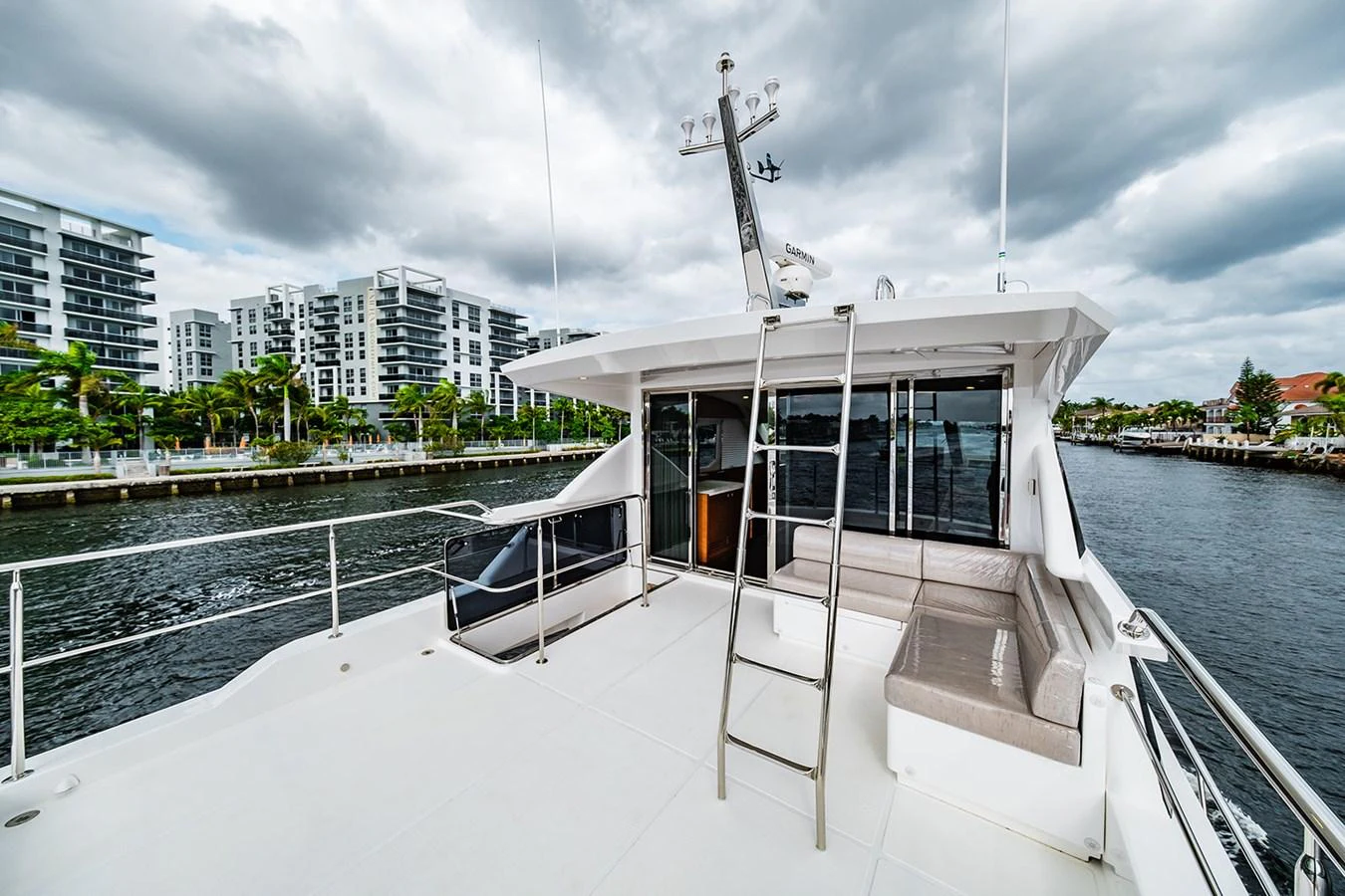 The yacht's flybridge offers a spacious and open area with seating and a ladder leading to the upper deck. aboard INDIGO Yacht for Sale