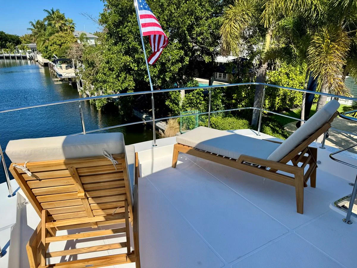 The sundeck features comfortable lounge chairs with a scenic view of the water and lush surroundings. aboard INDIGO Yacht for Sale