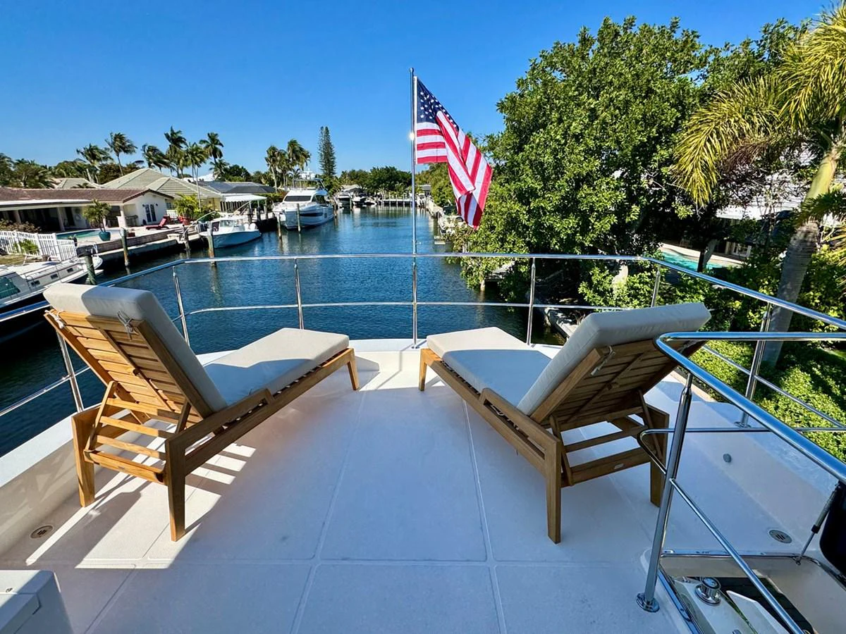 The sundeck offers a relaxing space with lounge chairs and a scenic view. aboard INDIGO Yacht for Sale