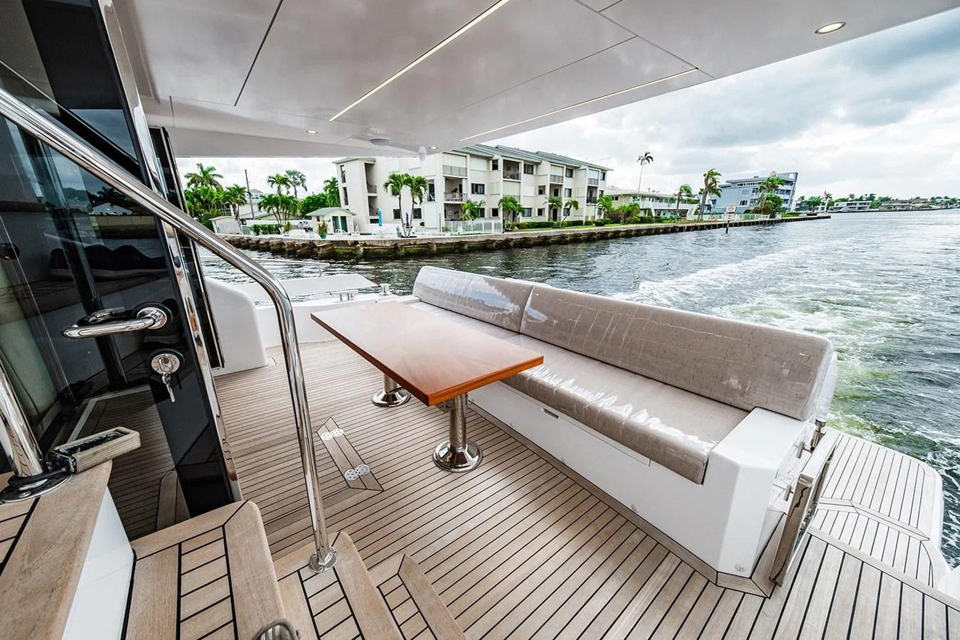 The aft deck features a comfortable seating area with a sleek table, perfect for enjoying the view. aboard INDIGO Yacht for Sale