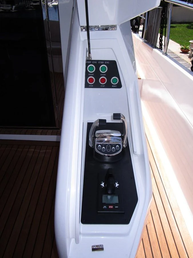 A close-up view of the yacht's helm station showcasing the control panel and throttle. aboard INDIGO Yacht for Sale