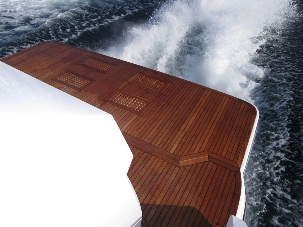 A view of the yacht's teak swim platform with water splashing behind. aboard INDIGO Yacht for Sale