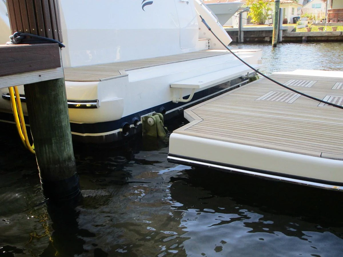 A close-up view of the yacht's stern and swim platform, docked at a marina. aboard INDIGO Yacht for Sale