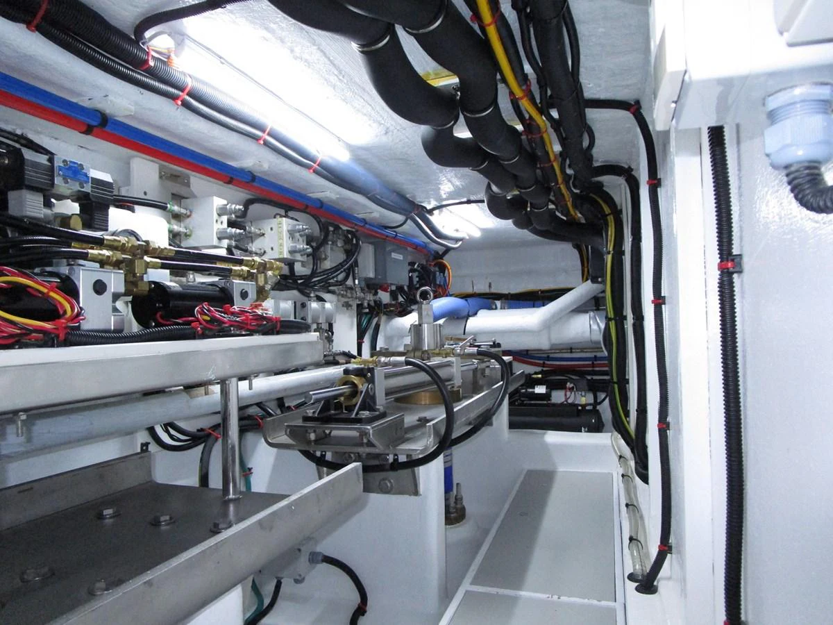 The image showcases the meticulously organized engine room with various mechanical components and wiring. aboard INDIGO Yacht for Sale