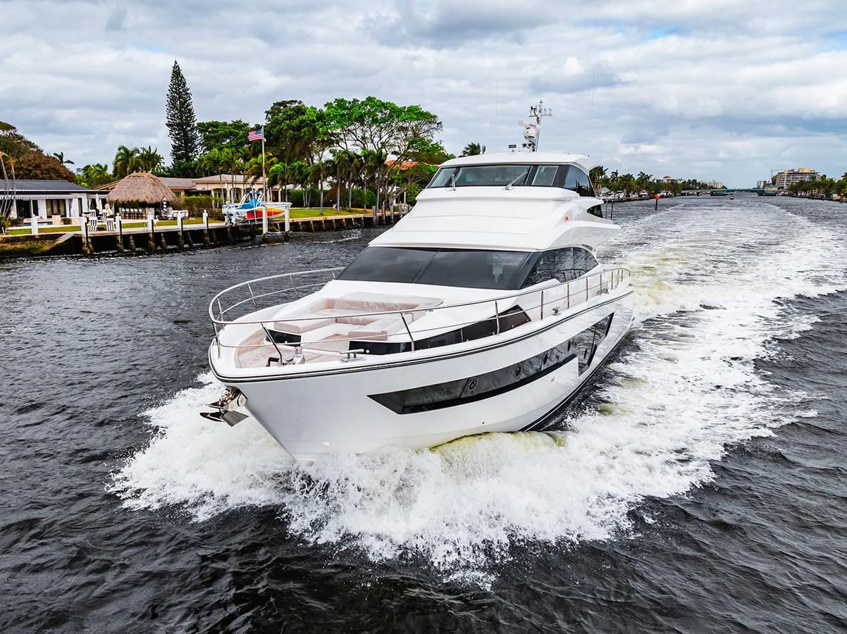 A sleek yacht cruises through a waterway, showcasing its modern design and powerful performance. aboard INDIGO Yacht for Sale