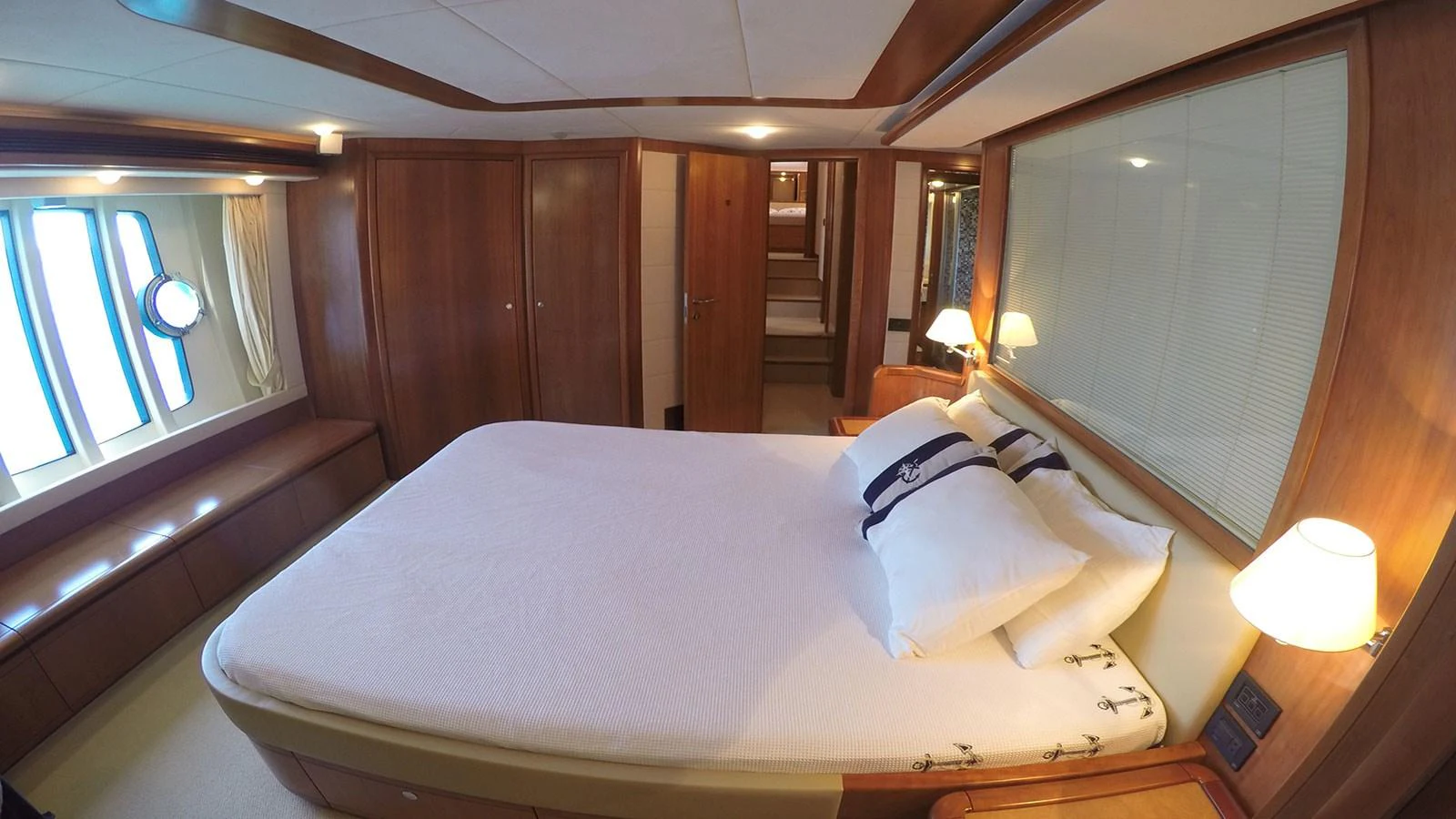The stateroom features a spacious bed with elegant wooden furnishings and soft lighting. aboard QUIT Yacht for Sale
