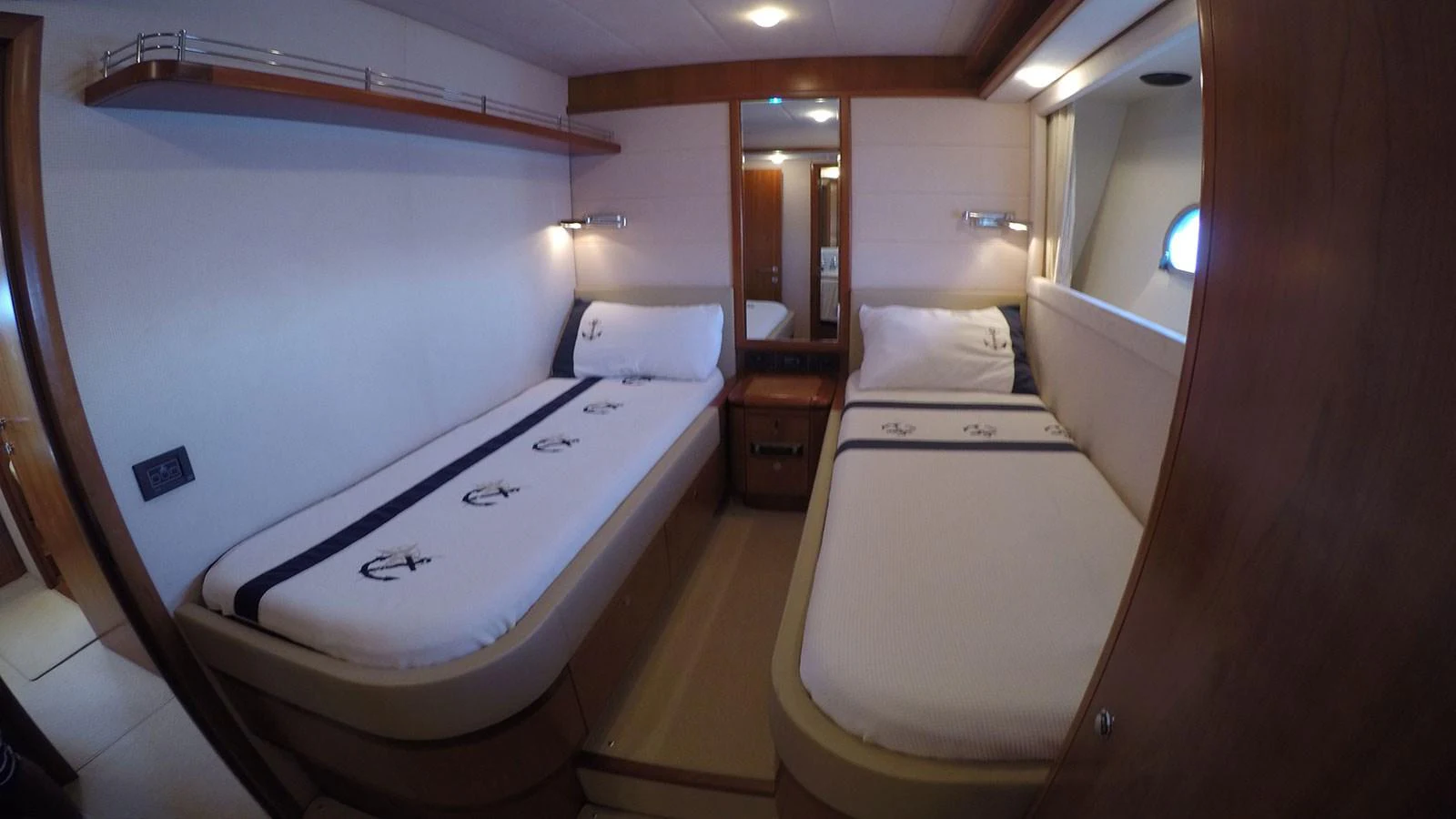 The guest cabin features two single beds with nautical-themed bedding and warm wooden accents. aboard QUIT Yacht for Sale
