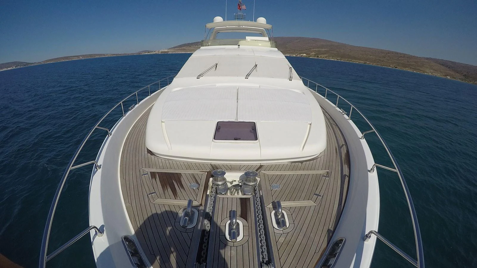 The yacht's foredeck features a spacious sunbathing area with plush cushions and a sleek design. aboard QUIT Yacht for Sale