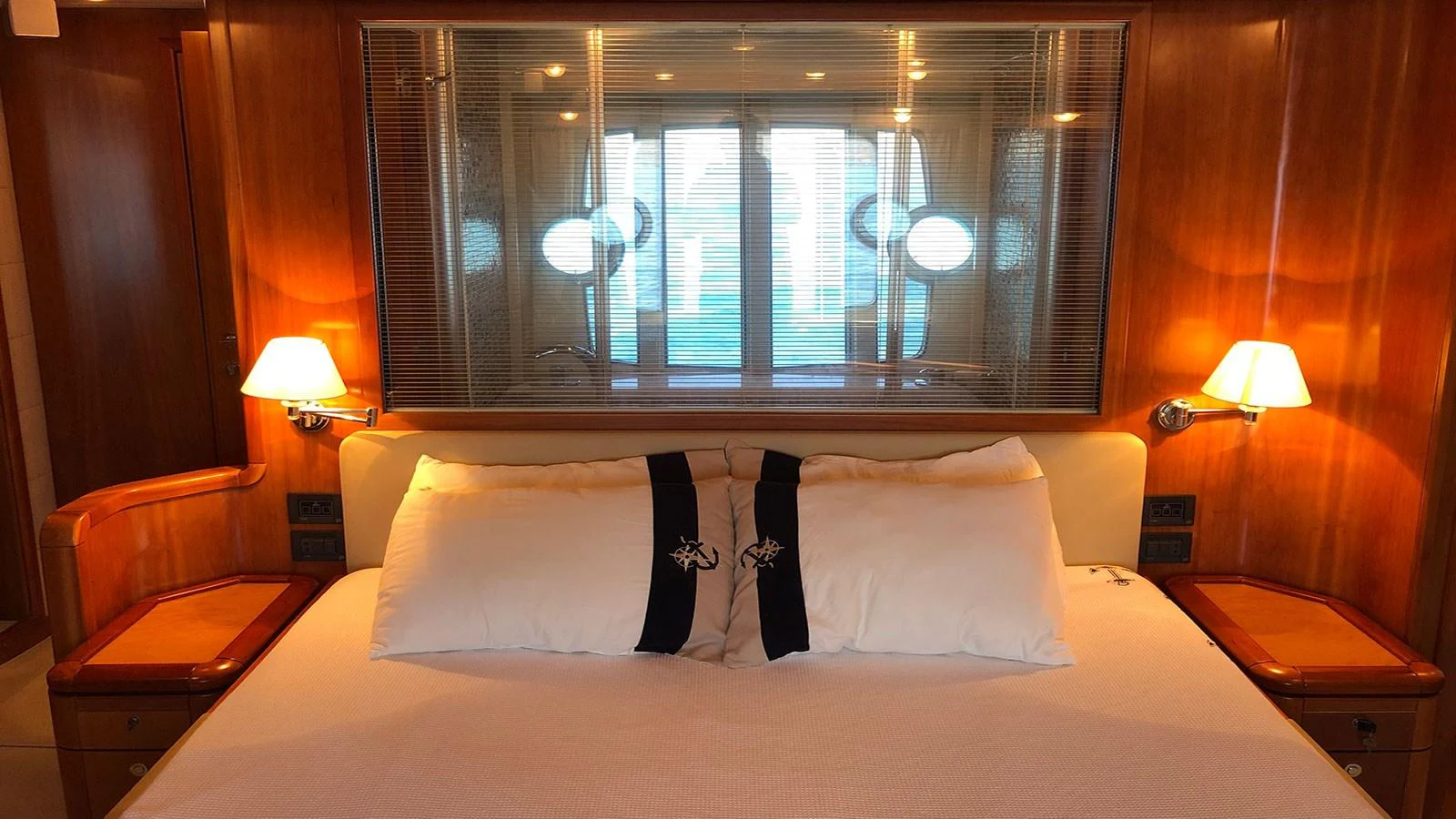 The master stateroom features a luxurious bed with elegant lighting and wood paneling. aboard QUIT Yacht for Sale