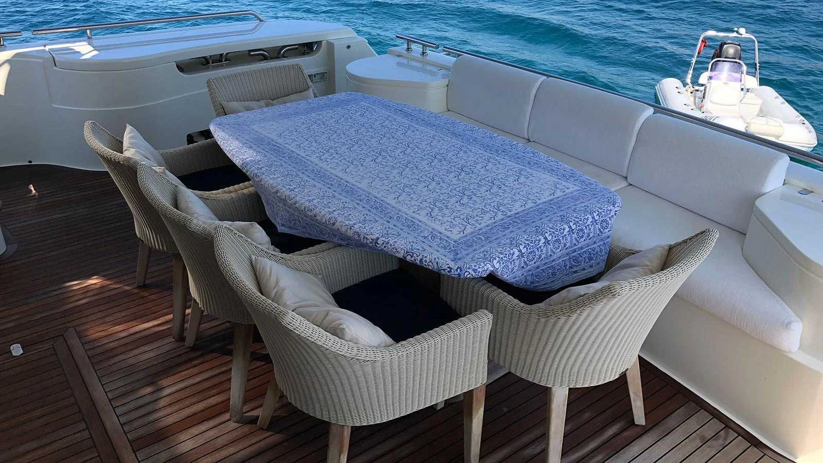 The aft deck features a stylish dining area with a large table and comfortable chairs, perfect for alfresco meals with a view of the sea. aboard QUIT Yacht for Sale