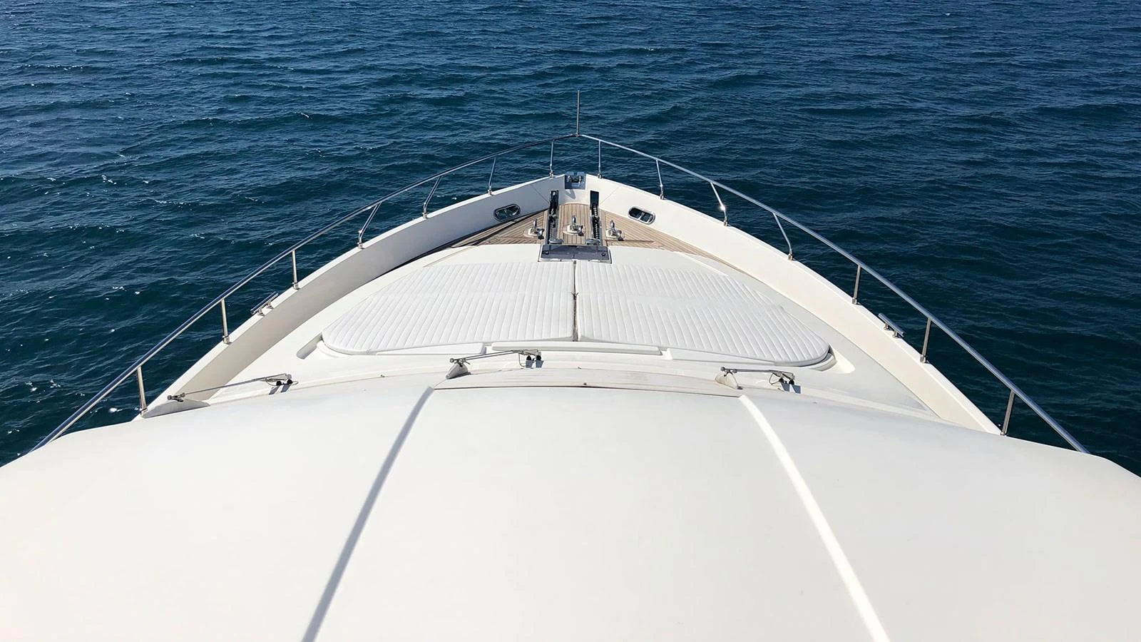 The yacht's bow cuts through the serene blue waters, showcasing its sleek design. aboard QUIT Yacht for Sale