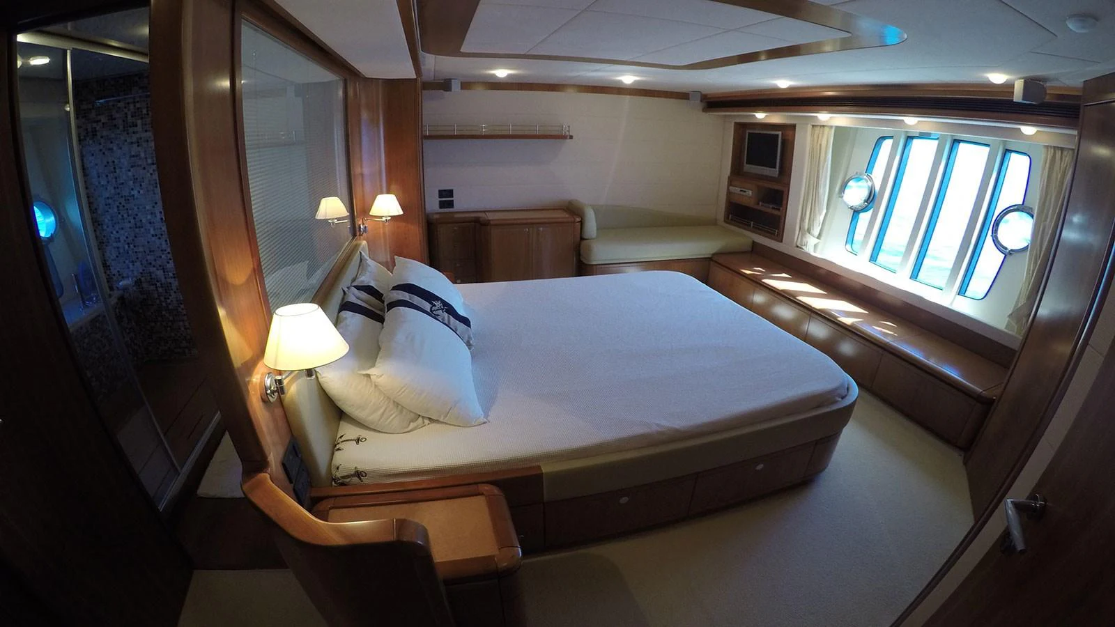A luxurious stateroom featuring a comfortable bed, ambient lighting, and large windows for natural light. aboard QUIT Yacht for Sale