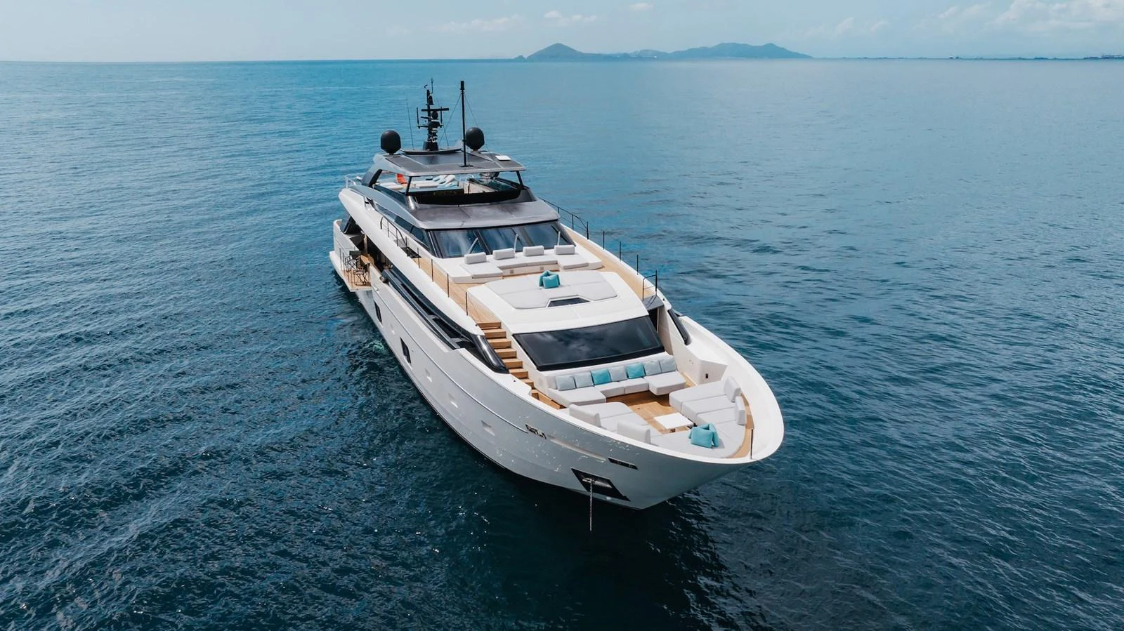 A sleek and modern yacht cruises on calm waters with a scenic backdrop. aboard AMBAR Yacht for Sale