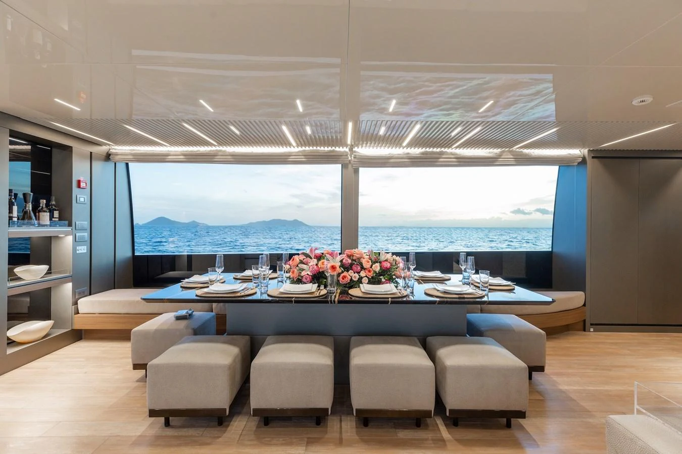 The yacht's dining area offers a luxurious setting with a beautifully set table and panoramic ocean views. aboard AMBAR Yacht for Sale
