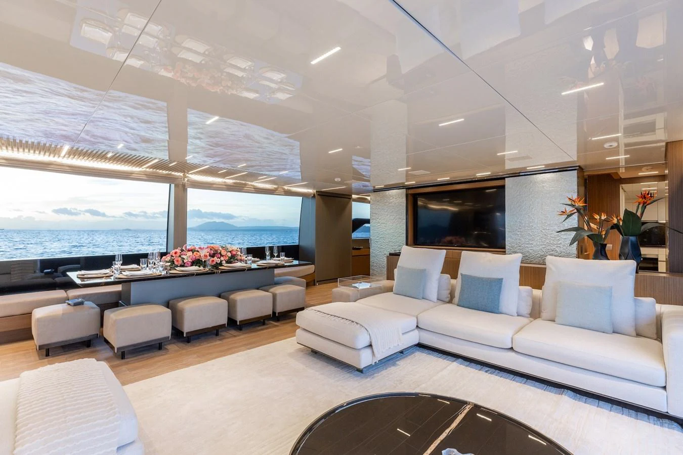 The spacious salon features luxurious seating and a large dining area with panoramic ocean views. aboard AMBAR Yacht for Sale