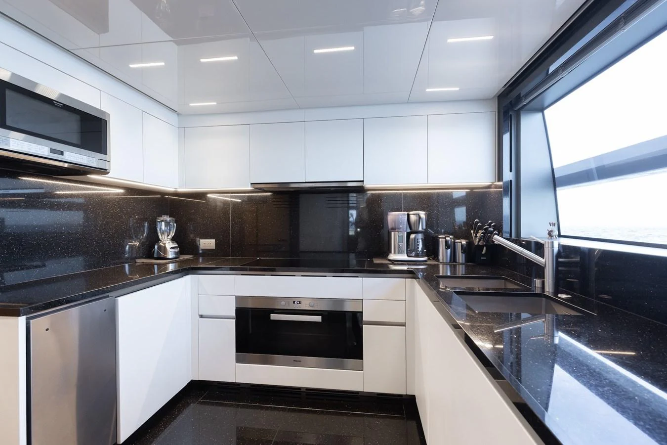 The yacht's galley features sleek modern appliances and a stylish black-and-white design. aboard AMBAR Yacht for Sale