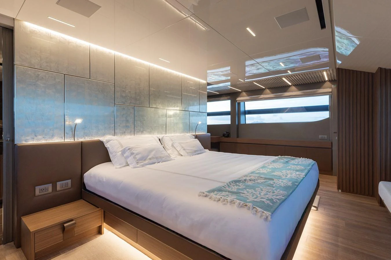 The master stateroom features a luxurious bed with modern lighting and elegant decor. aboard AMBAR Yacht for Sale