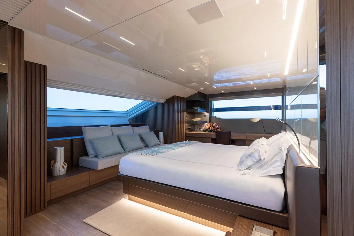 The master stateroom features a luxurious bed, ample seating, and modern decor with natural light streaming in. aboard AMBAR Yacht for Sale