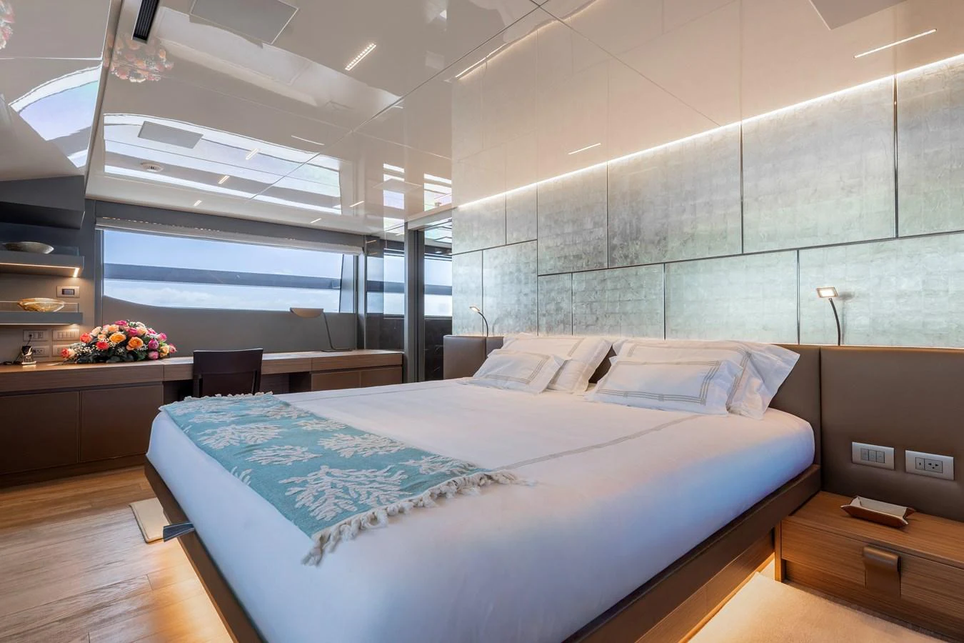 The master stateroom features a luxurious bed with elegant lighting and modern decor. aboard AMBAR Yacht for Sale