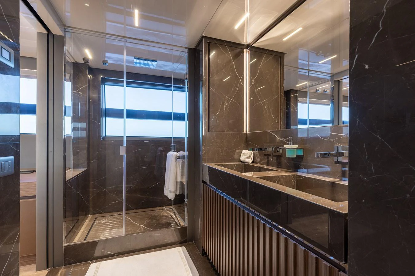 The yacht's bathroom features luxurious dark marble finishes and modern fixtures. aboard AMBAR Yacht for Sale