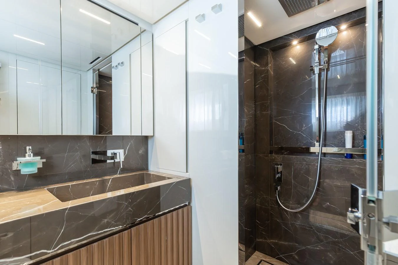A luxurious yacht bathroom featuring a sleek shower and modern fixtures. aboard AMBAR Yacht for Sale