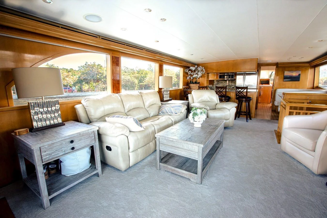 The salon features plush seating, wooden accents, and large windows for a bright and inviting atmosphere. aboard KRISTIN LEE Yacht for Sale