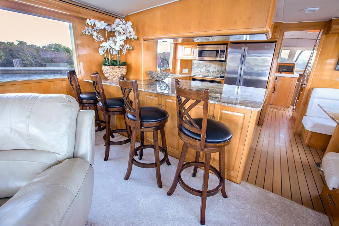 The galley features a stylish bar area with wooden stools and modern appliances. aboard KRISTIN LEE Yacht for Sale
