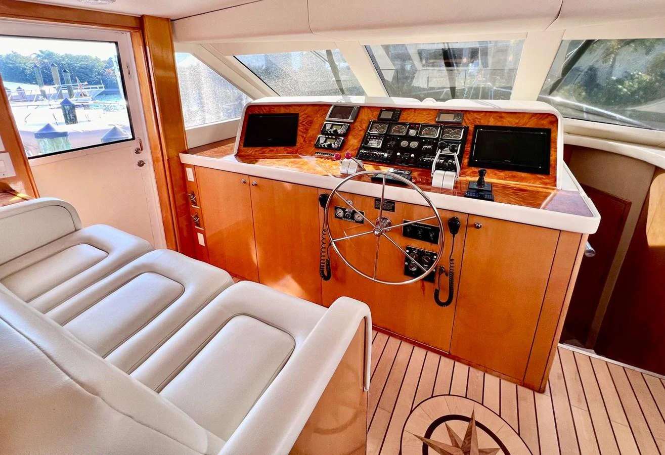 The helm station features a sophisticated control panel with plush seating and panoramic windows. aboard KRISTIN LEE Yacht for Sale