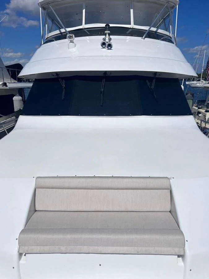 The yacht's exterior features a sleek white design with a comfortable seating area on the deck. aboard KRISTIN LEE Yacht for Sale
