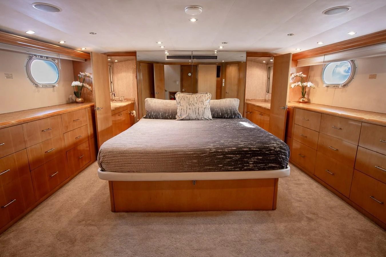 The master stateroom features a spacious bed with elegant wood cabinetry and soft lighting. aboard KRISTIN LEE Yacht for Sale