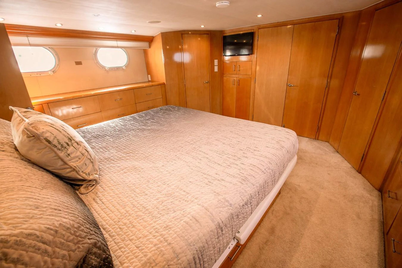 The stateroom features a spacious bed, warm wood finishes, and ample storage. aboard KRISTIN LEE Yacht for Sale
