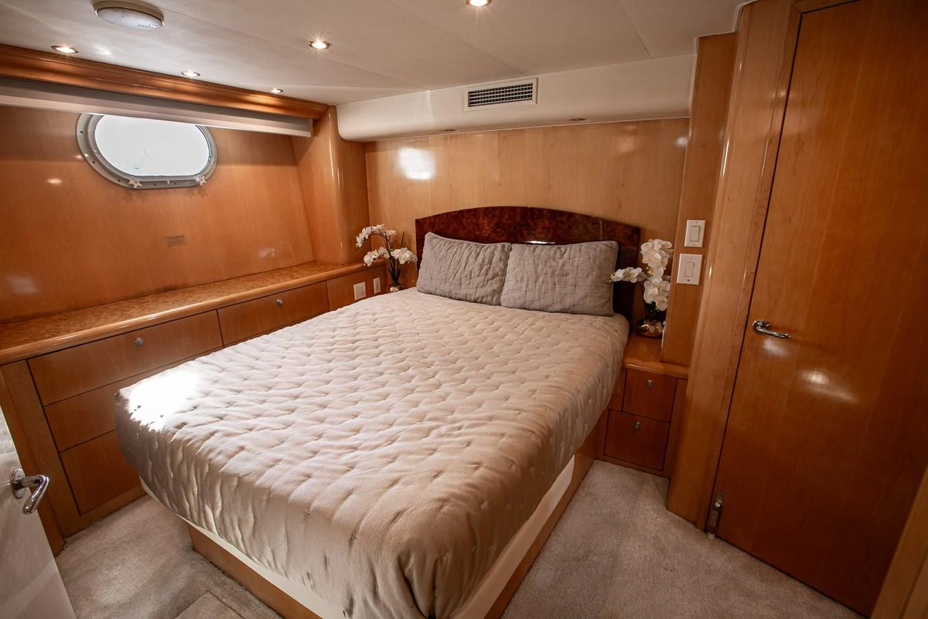 The stateroom features a comfortable bed with elegant wood paneling and soft lighting. aboard KRISTIN LEE Yacht for Sale