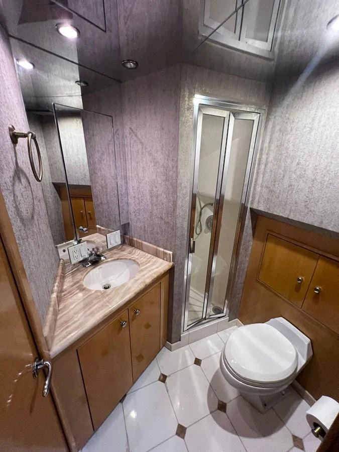 The yacht's bathroom features a compact yet elegant design with a shower, sink, and toilet. aboard KRISTIN LEE Yacht for Sale