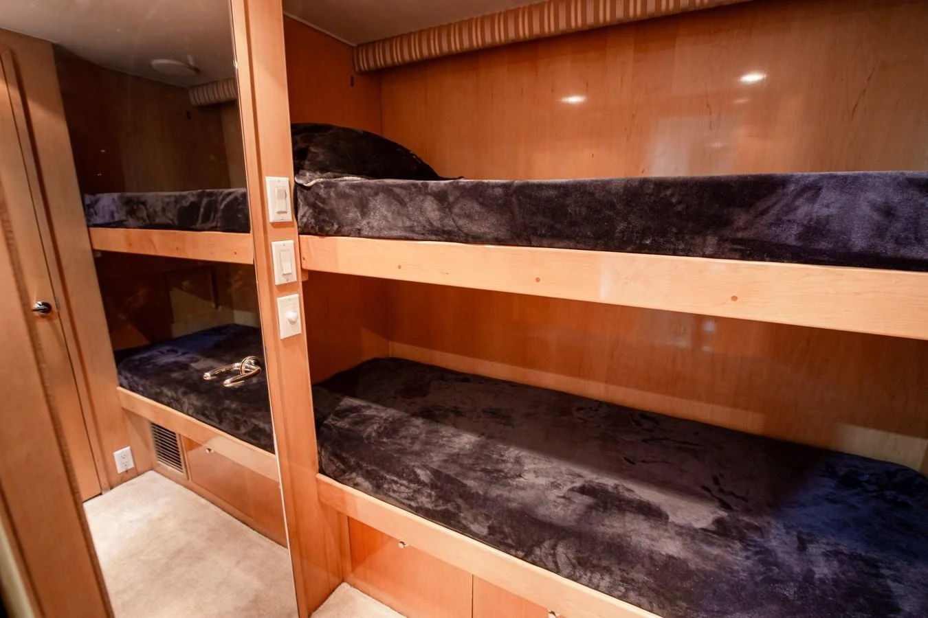 The cozy bunk room features two sets of plush, dark-colored bunk beds with ample storage space. aboard KRISTIN LEE Yacht for Sale
