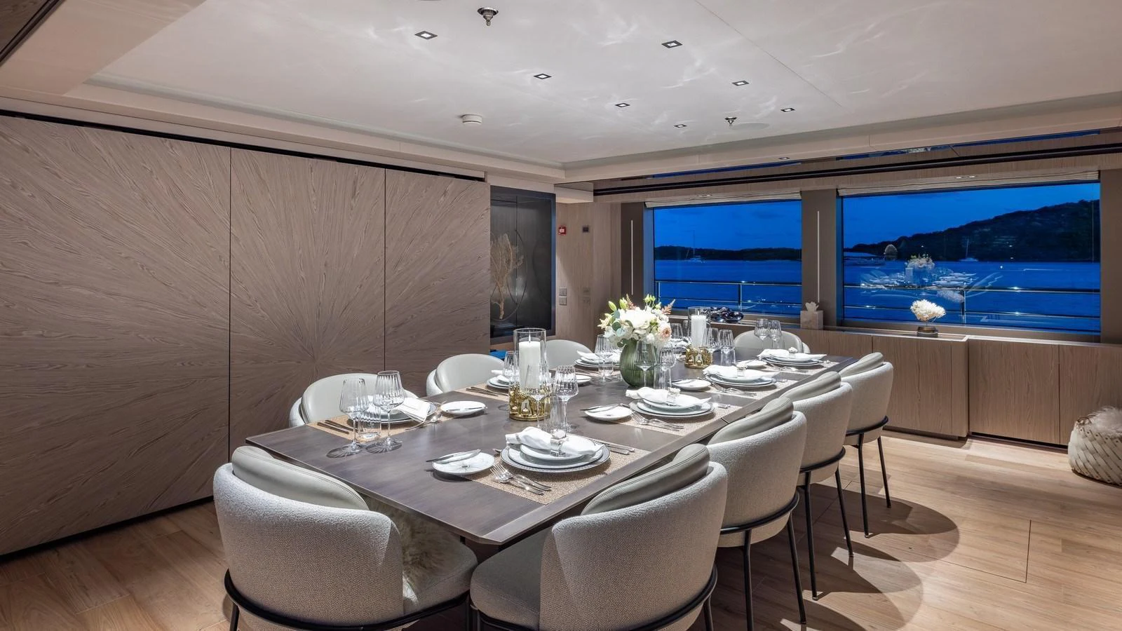The yacht's dining area features a sophisticated table setting with a view of the sea through large windows. aboard GIOIA Yacht for Sale