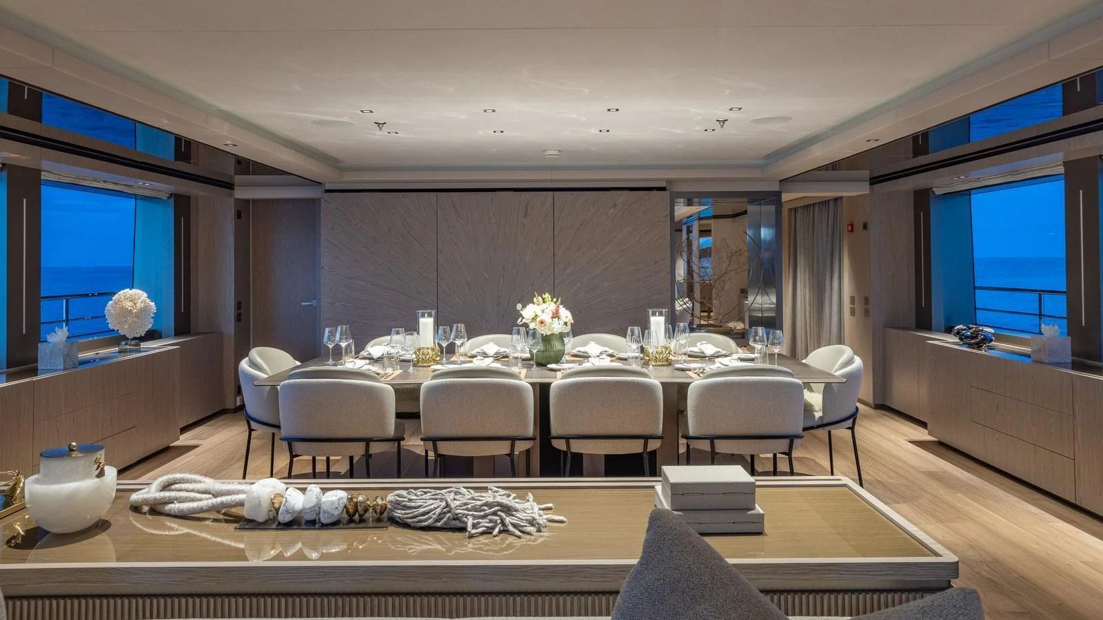 The elegant dining area features a large table set for a formal meal, surrounded by plush seating and ambient lighting. aboard GIOIA Yacht for Sale