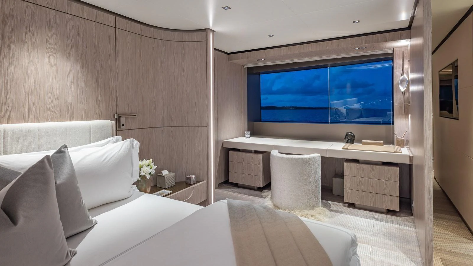 A luxurious stateroom featuring a large bed, a desk area, and a scenic window view. aboard GIOIA Yacht for Sale