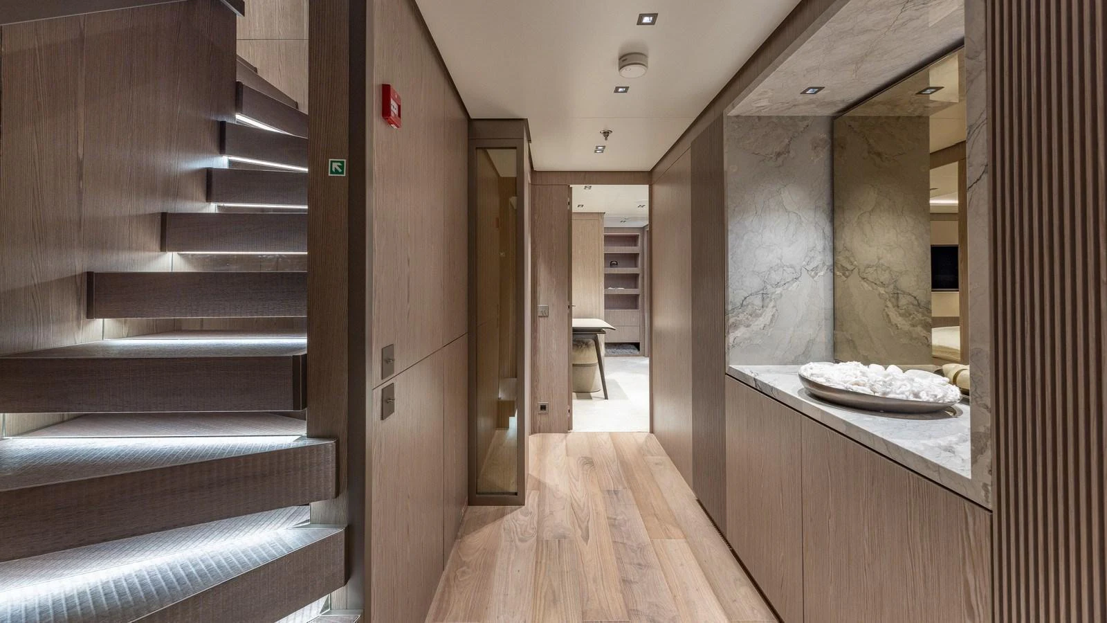 The yacht's interior features a modern hallway with sleek wooden finishes and ambient lighting. aboard GIOIA Yacht for Sale