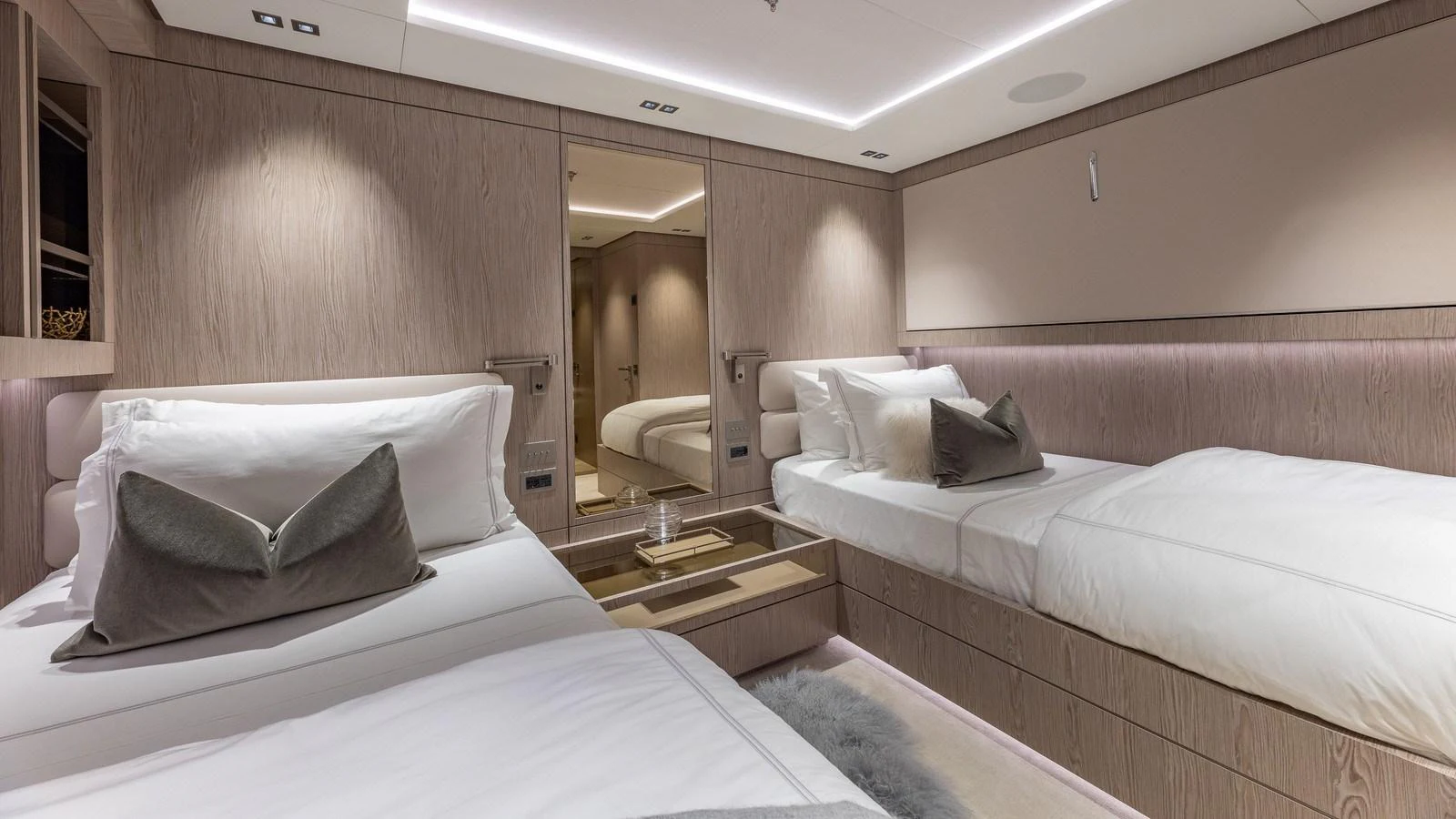 The guest stateroom features twin beds with elegant bedding and modern lighting. aboard GIOIA Yacht for Sale