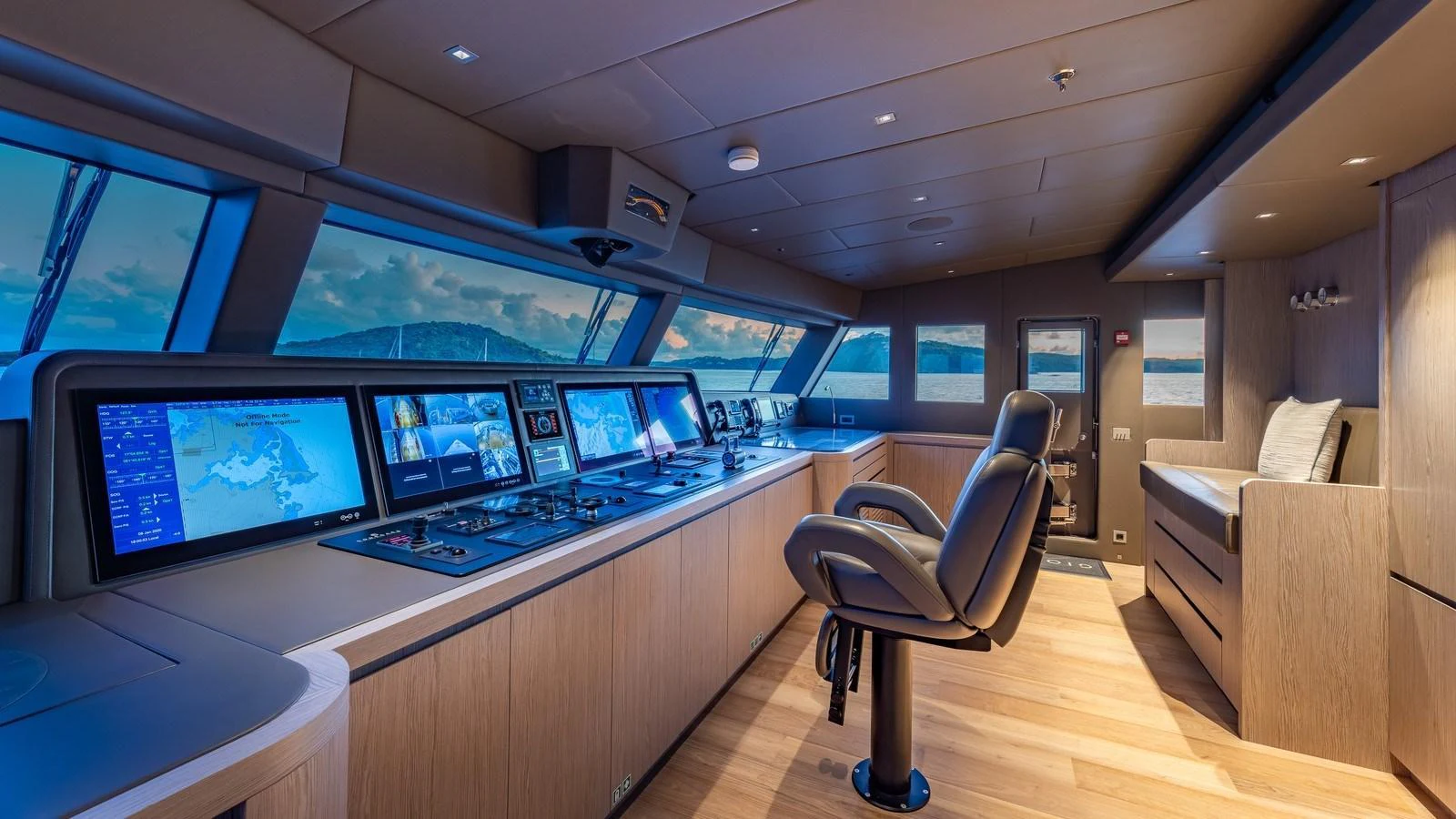 The helm station features advanced navigation systems and a comfortable captain's chair, set against a backdrop of panoramic windows. aboard GIOIA Yacht for Sale
